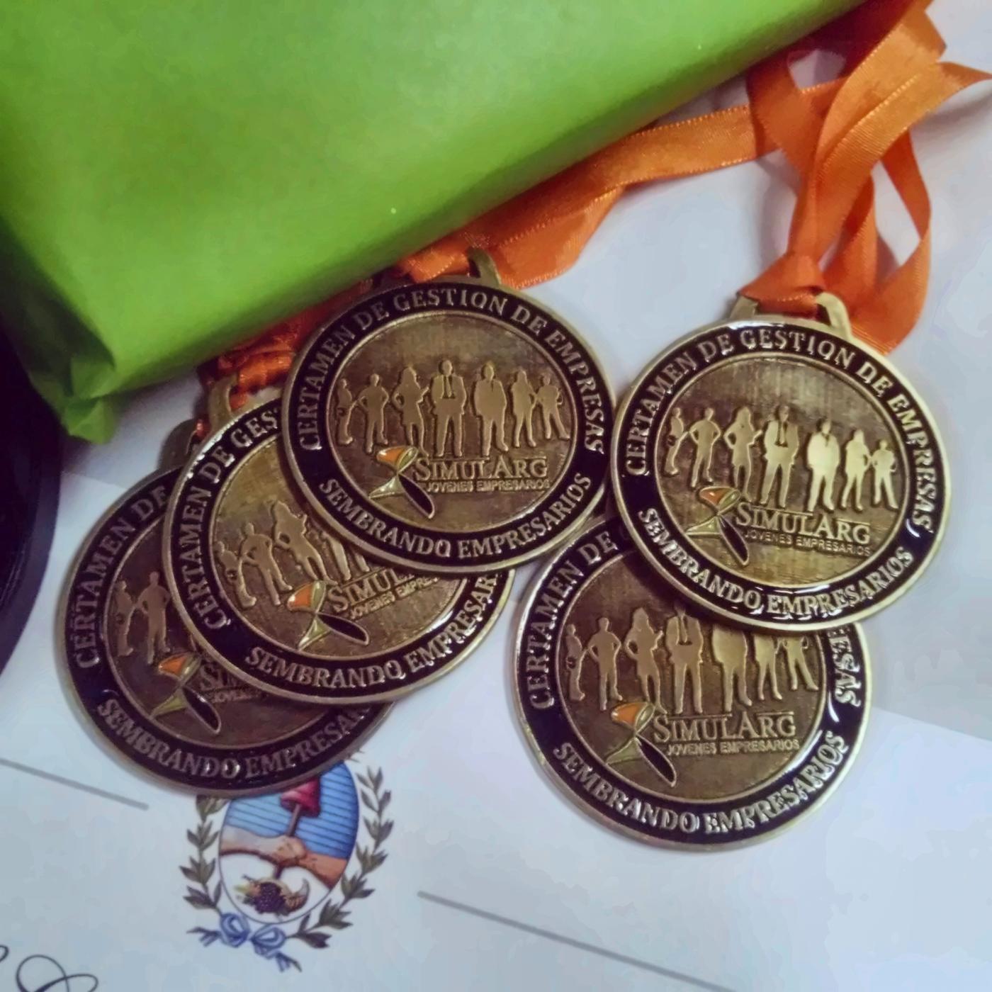 Medallas del certamen Sembrando Empresarios con cinta naranja