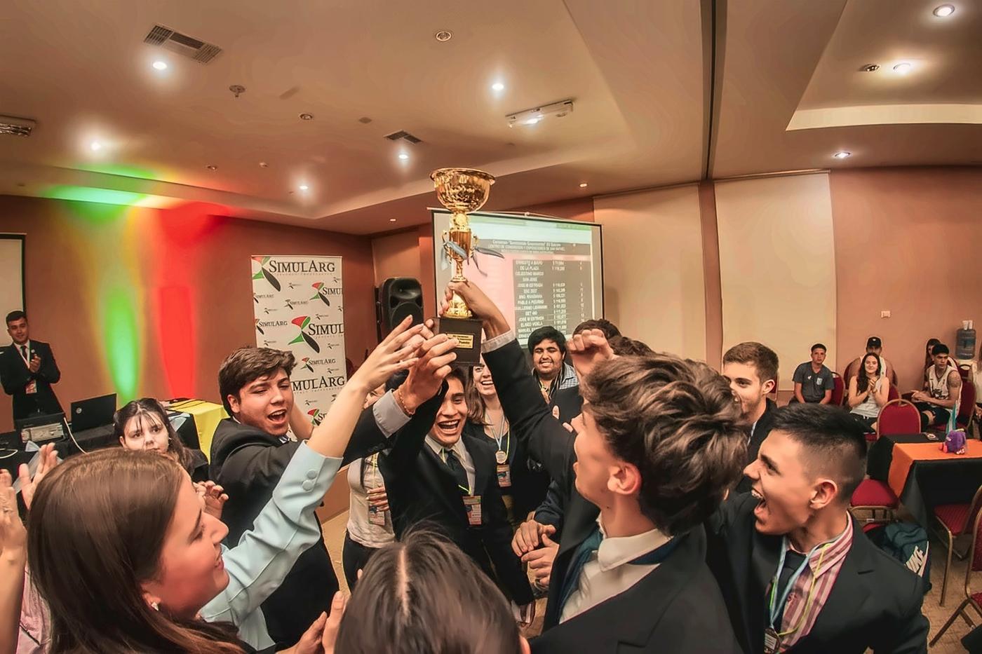 Equipo campeón festejando con la copa junto a sus compañeros en una Final de Sembrando Empresarios