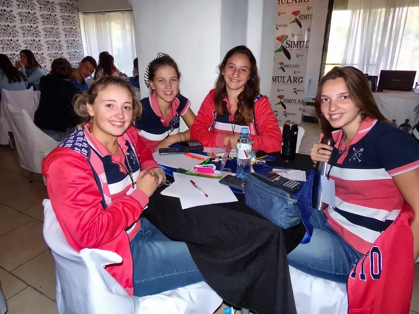 Equipo de estudiantes sonriendo en su mesa de trabajo