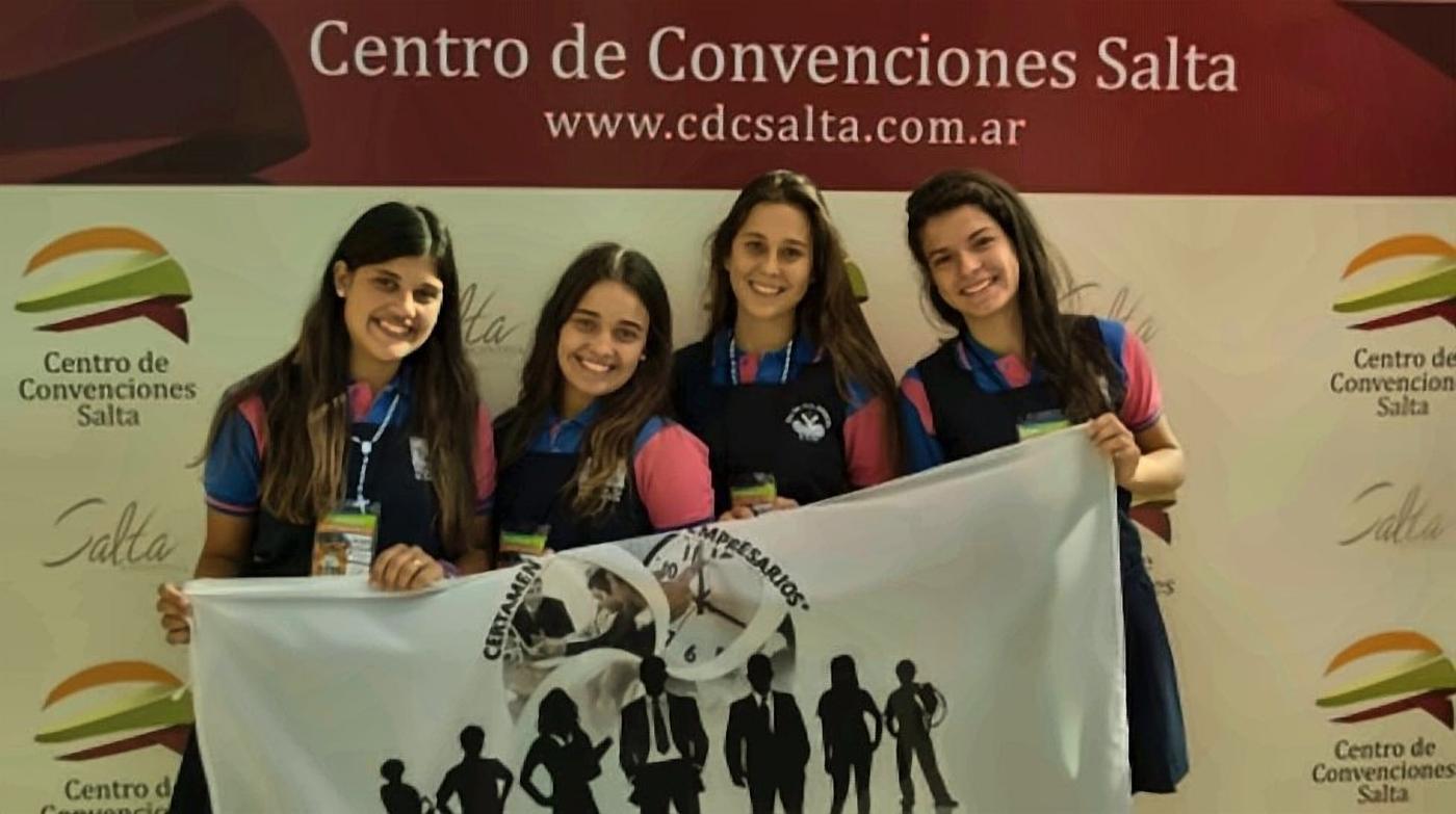Equipo de estudiantes con la bandera del certamen en el Centro de Convenciones de Salta