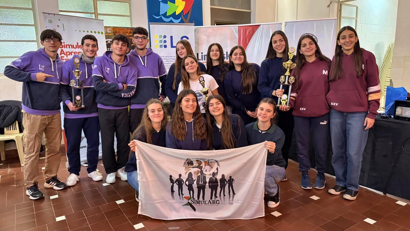 Equipos ganadores de una instancia regional con sus trofeos y la bandera del certamen